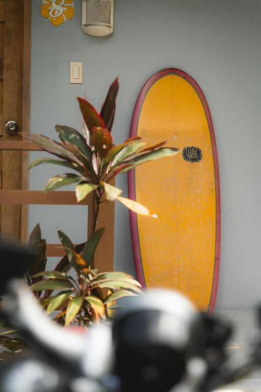 Yellow surfboard leaning against a wall, part of the surf gear to pack for a Baler trip