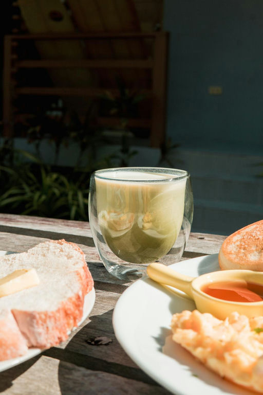 Matcha latte and healthy breakfast plate on an outdoor table at The Shala Grounds, Kahana Baler