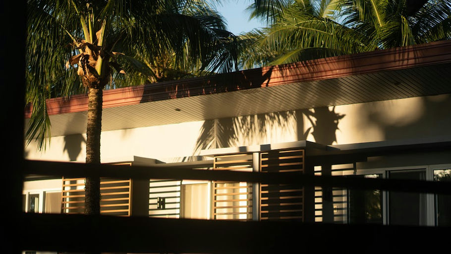 Kahana Baler's open-air building and palm trees at golden hour in Cemento, Baler